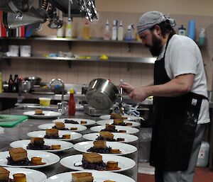 Casey Chef Eddie Dawson plating up pork belly, saffron pommes fondant and red cabbage for a mid-winter lunch.