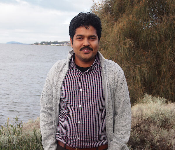 Dr Bishakhdatta Gayen standing beside the Derwent River in Hobart.