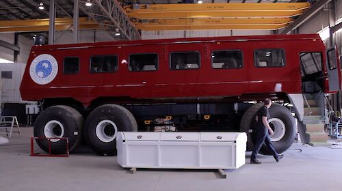 Bus in a workshop with a man walking past