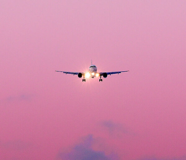 The Airbus A319 in mid air with a sunrise behind.