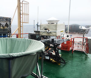 A balloon filling station (green object on left), a cloud radar (centre) and wind profiling radar (right) on the Aurora Australis.