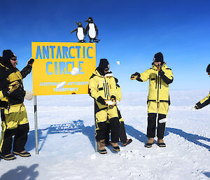 Standing in Antarctica next to a sign