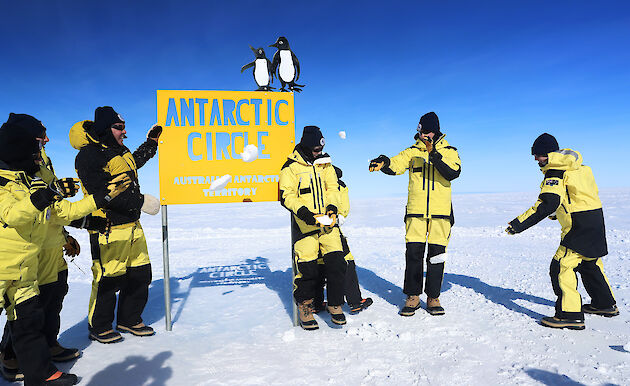 Standing in Antarctica next to a sign