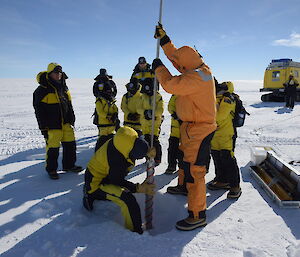 Children standing around a drill