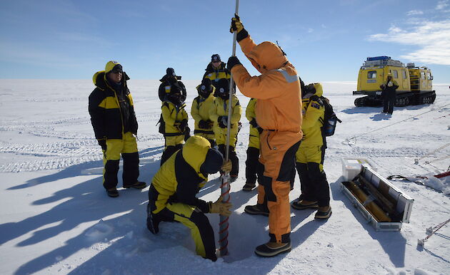 Children standing around a drill