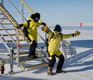 Child stepping onto the ice after walking down the stairs from the plane.