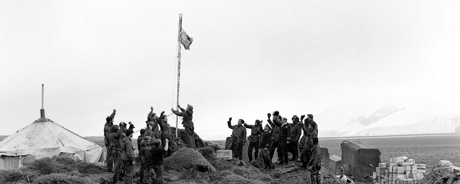 A man raises the flag in a black and white photo.