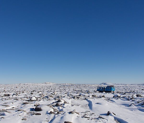 A flat, rocky snow-covered valley.