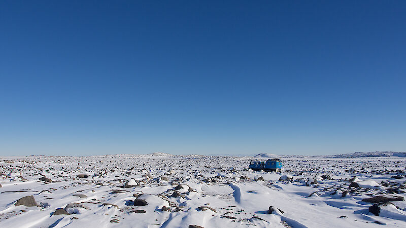 A flat, rocky snow-covered valley.