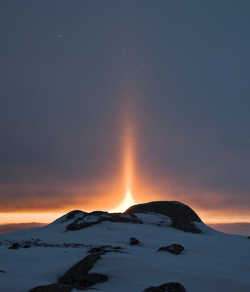 Parhelion or sun dogs on the Antarctic horizon. Sun dogs are created by light interacting with ice crystals in the atmosphere. Sun dogs typically appear as two subtly coloured patches of light to the left and right of the Sun, approximately 22° distant and at the same elevation above the horizon as the Sun.