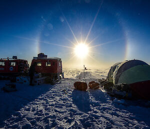 A Hägglunds and polar pyramid tent in the glow of the solar halo at Dome Summit South, Law Dome