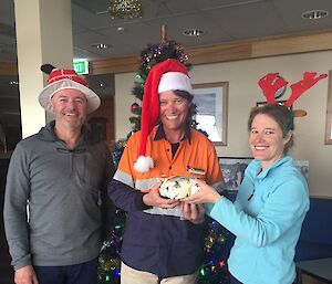 three people exchanging gifts