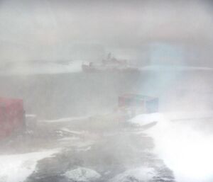 Mawson research station in blizzard conditions, with the Aurora Australis aground