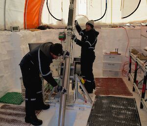 Setting up an ice core drill in a large tent.