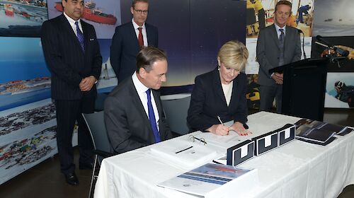 Ministers sitting at the table signing a document.