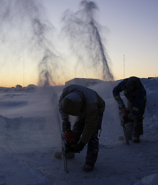 Expeditioners use a chainsaw to cut into the sea ice at Mawson station in preparation for their midwinter swim