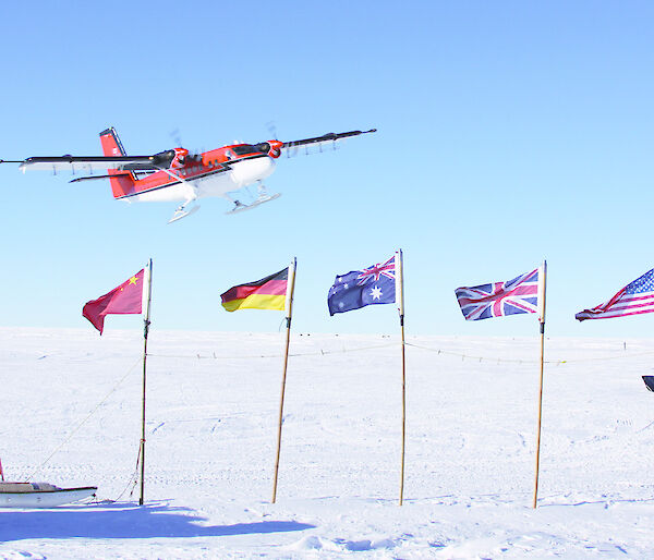 Plane taking off over flags