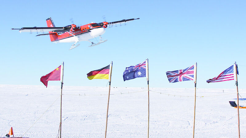 Plane taking off over flags