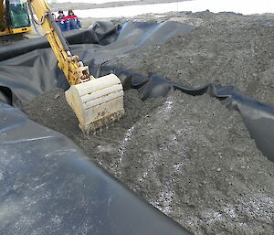 At the Brazilian remediation site, an impermeable material is used to line the hole and the contaminated soil is replaced.