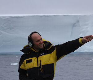 Dr Brian Miller on deck pointing in the direction of the next whale