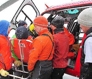 The expeditioner is transferred from the helicopter to the Aurora Australis after being flown from Davis station