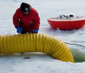 Dr Jonny Stark lowers the slinky into a semi-enclosed chamber under the ice to increase carbon dioxide concentrations as part of the antFOCE experiment into the effects of ocean acidification