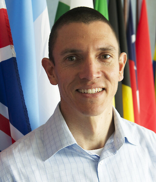 New CEP Chair, Ewan McIvor, standing in front of many nations’ flags