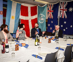 Expeditioners at Casey enjoy a Midwinter meal and toast absent friends