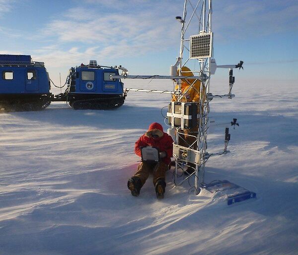 An expeditioner downloads data from an Automatic Weather Station