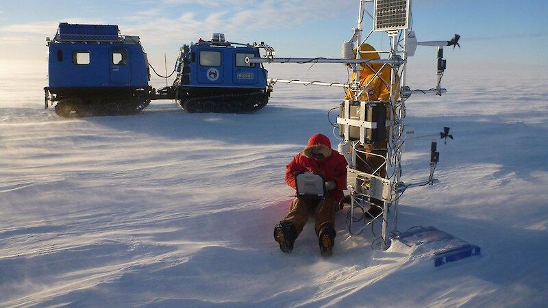 An expeditioner downloads data from an Automatic Weather Station