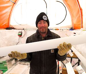 Dr Mark Curran holds up a one-metre length of ice core.