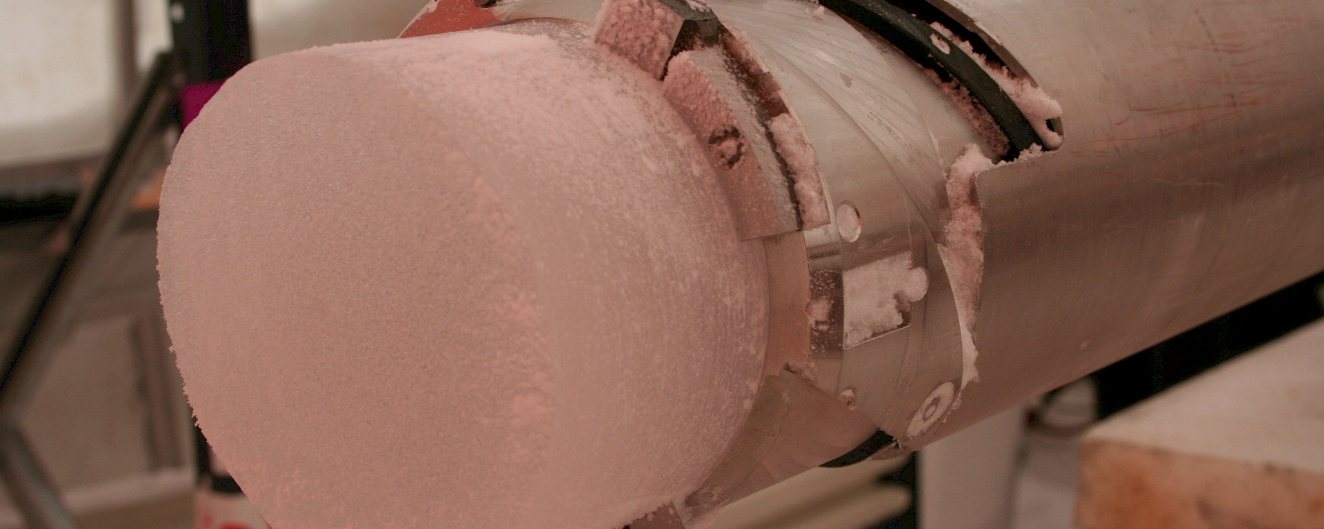 The end of an ice core protruding from the drill.