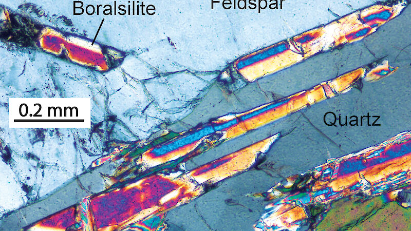 A photomicrograph of brightly coloured crystals of boralsilite