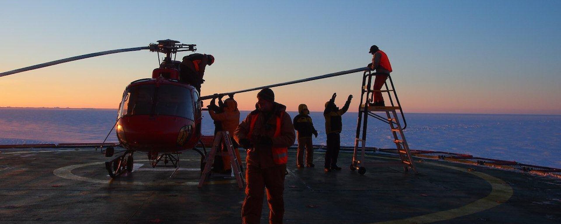 Helicopter on the deck of the Aurora Australis having its blades removed