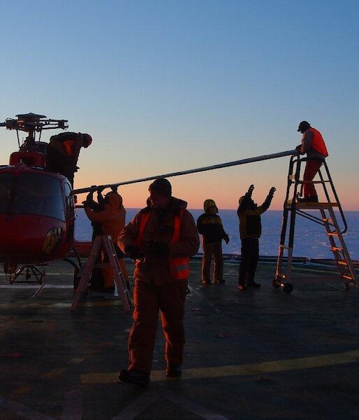 Helicopter on the deck of the Aurora Australis having its blades removed