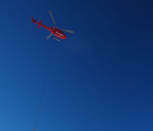 Helicopter carrying sling-load of cargo underneath