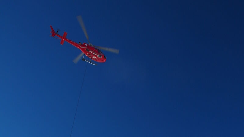 Helicopter carrying sling-load of cargo underneath