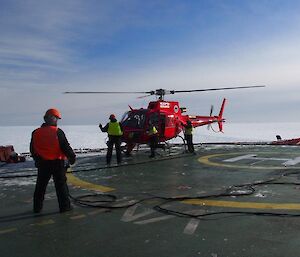 Refueling a helicopter on the deck of the Aurora Australis