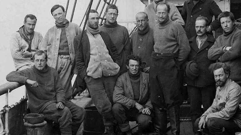 Very old photograph of a group of thirteen men on a ship