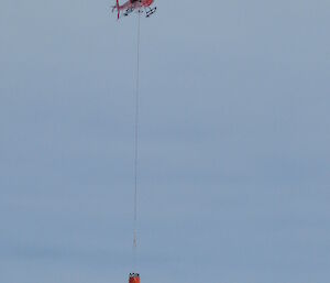 A Bambi Bucket slung underneath a helicopter in Antarctica.