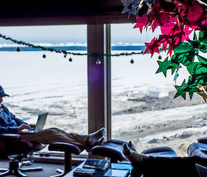 Expeditioners relax in the Davis station living quarters surrounded by Christmas decorations