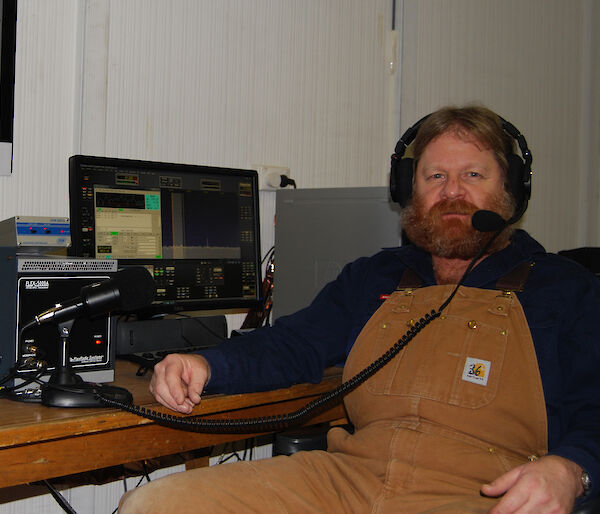 Craig Hayhow sitting in front of his radio at Mawson station.