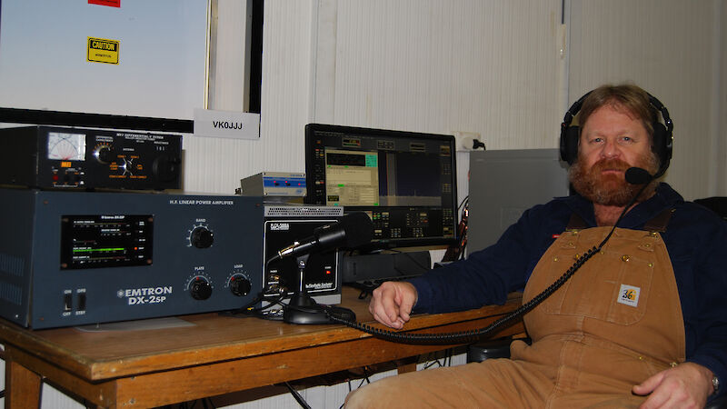 Craig Hayhow sitting in front of his radio at Mawson station.