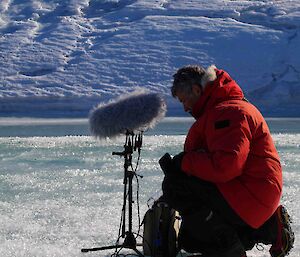 Artist Philip Samartzis using a microphone on the ice