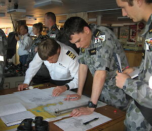 Captain and another person looking at a chart on the bridge of a ship