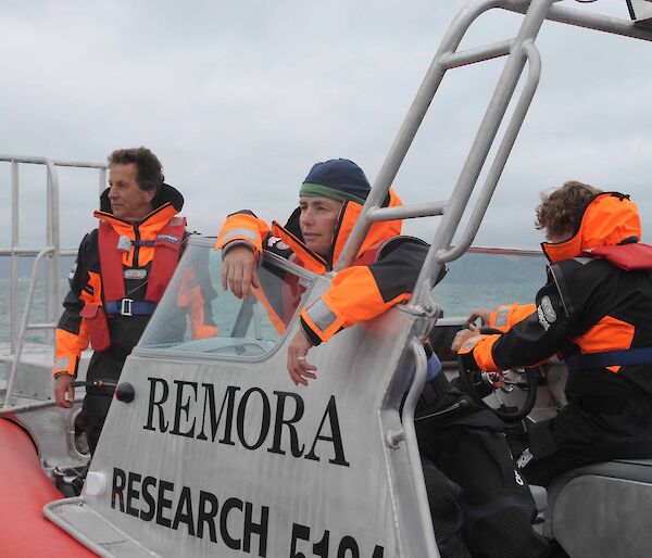 Two people in wet weather gear in a small boat.