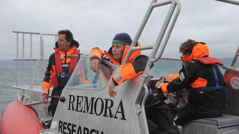 Two people in wet weather gear in a small boat.