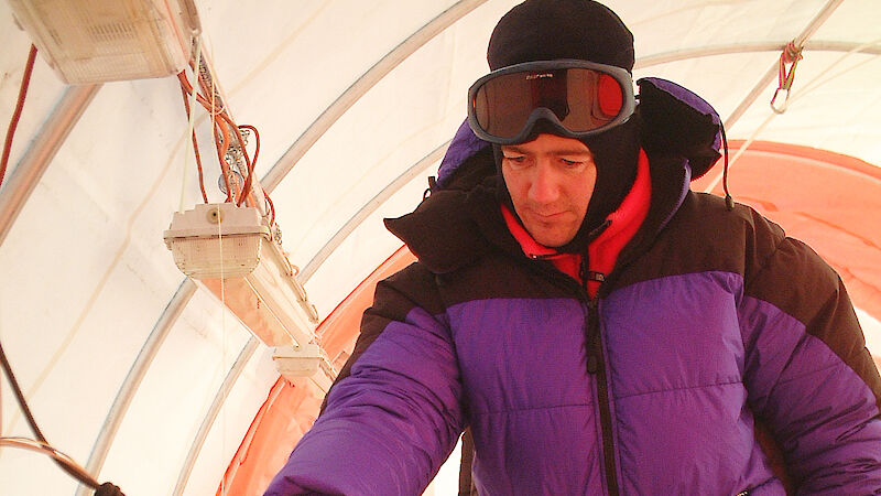 Scientist inspects an ice core in a field drill tent