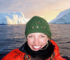 Dr Helena Baird in a boat with Antarctic icebergs behind.