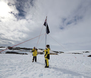 Two expeditioners raising the flag